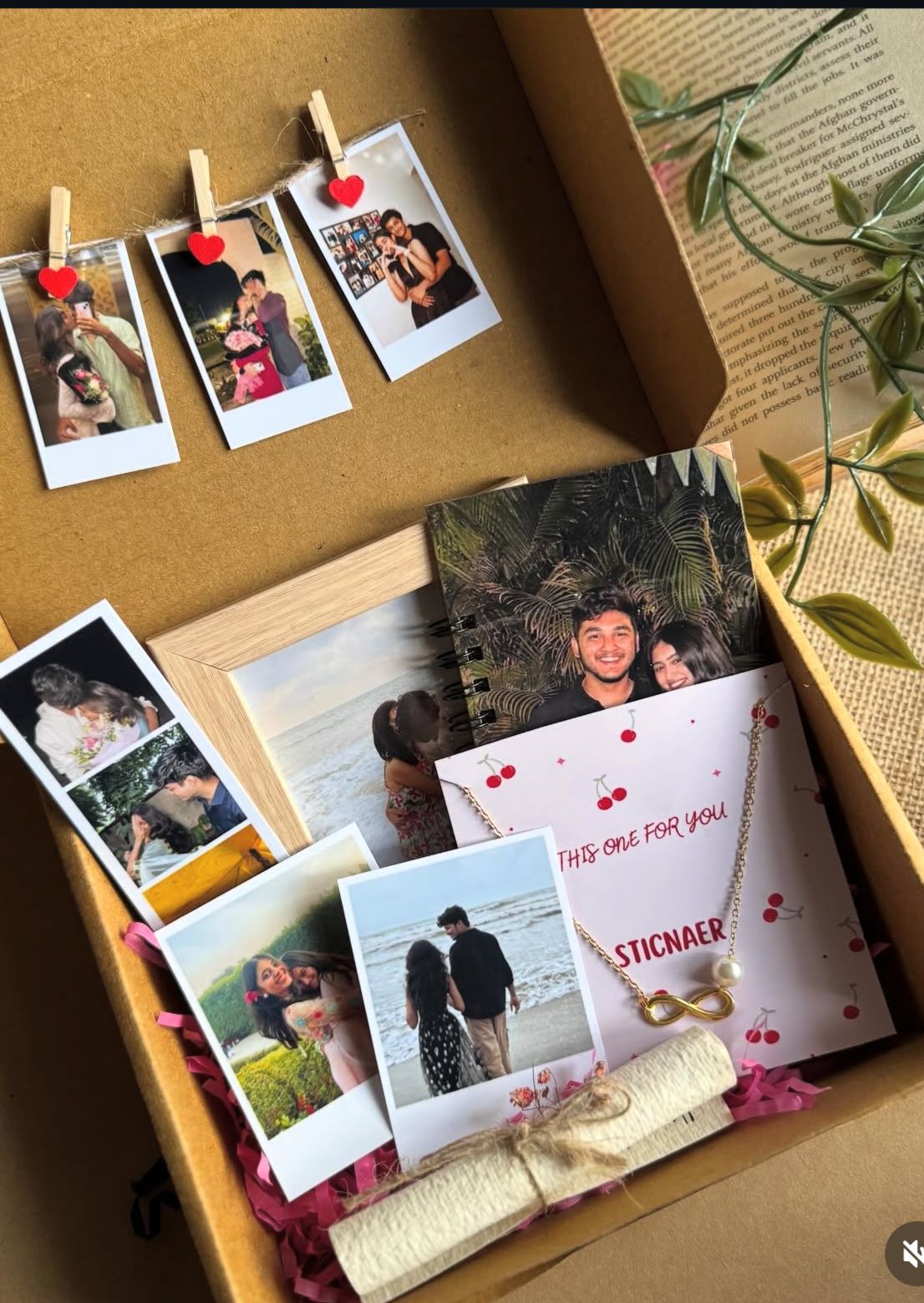 Valentine’s Day gift box with personalized handmade items including printed couple photos, greeting card, and small booklet arranged neatly inside a cardboard box.