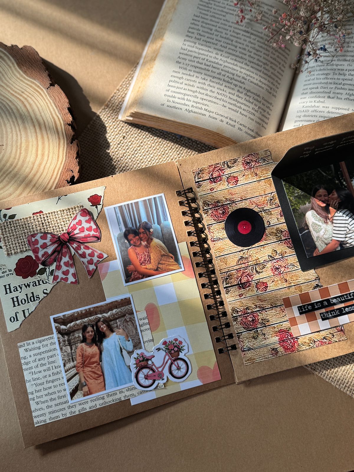 Open scrapbook with photos and decorative elements on a wooden surface